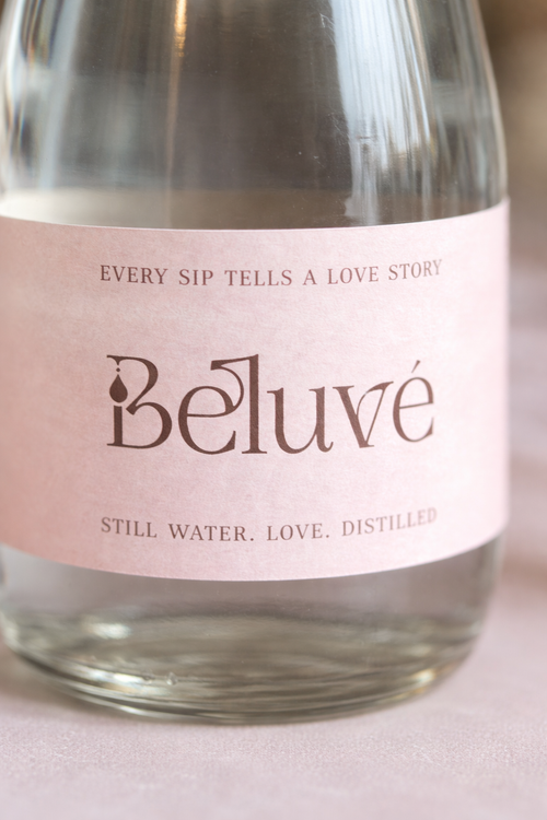Close-up of the label of a bottle of Beluvé water with a blush label on a light background